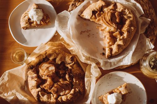 Free Delicious rustic apple pie slices with whipped cream on a wooden table, showcasing homemade baking delights. Stock Photo