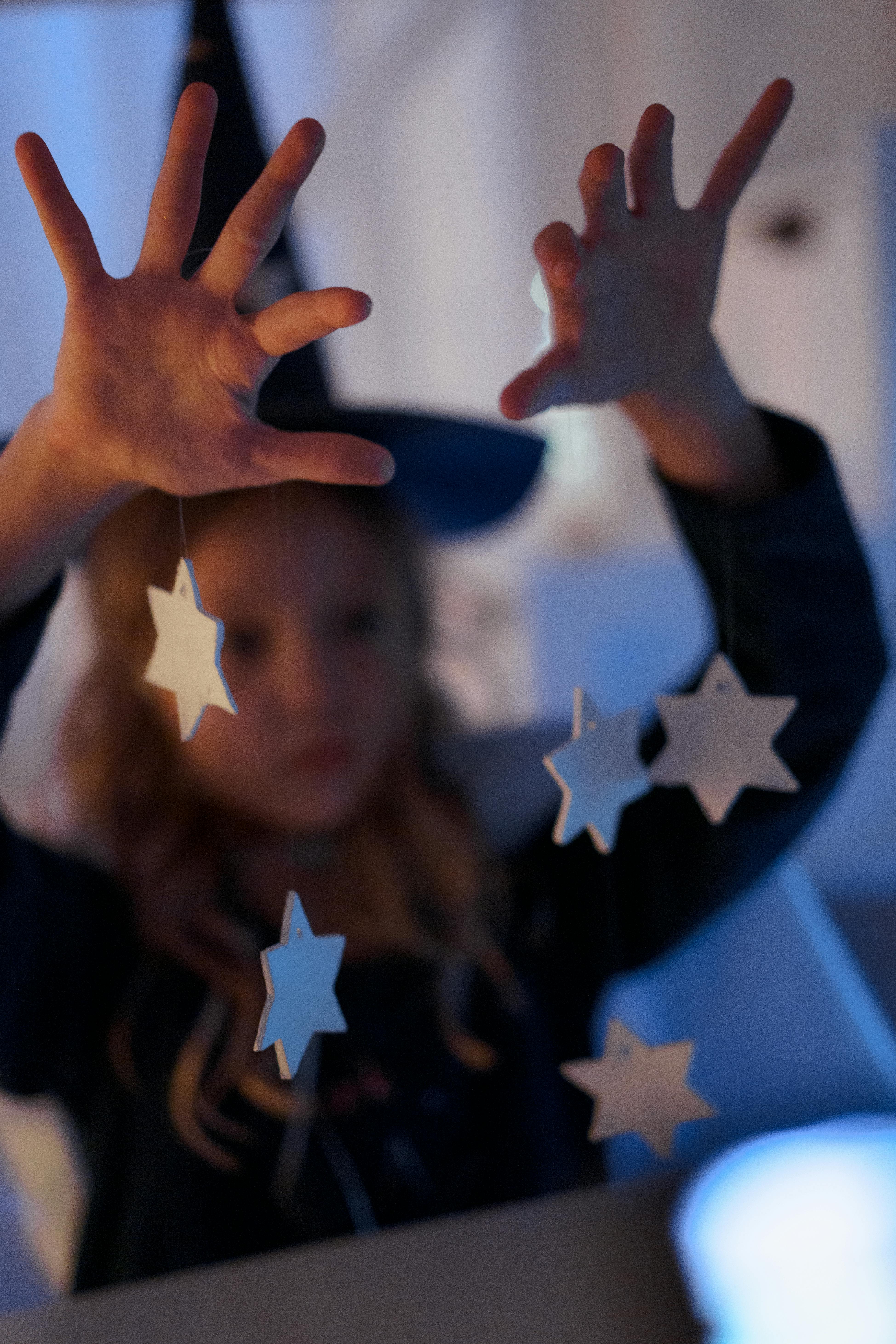 Boy in Black Crew Neck Shirt Holding White Star Paper