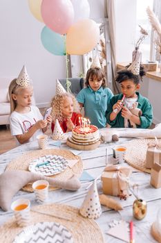 A joyful children's birthday party with cake, balloons, and decorations.