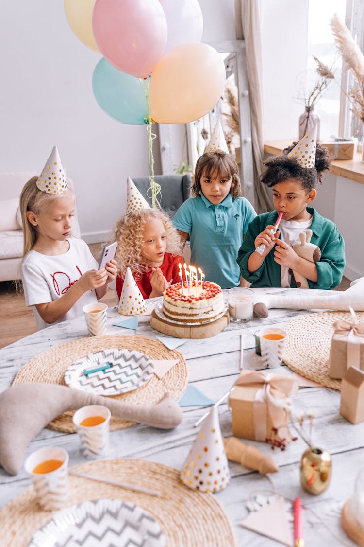 Children Admiring Birthday Cake At Party