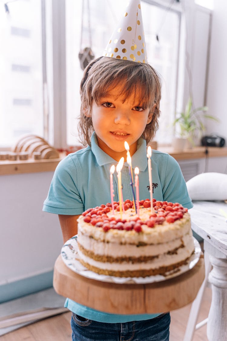 A Boy Holding A Birthday Cake