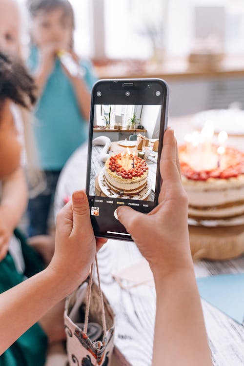 Person Holding Black Smartphone Taking Photo of Cake