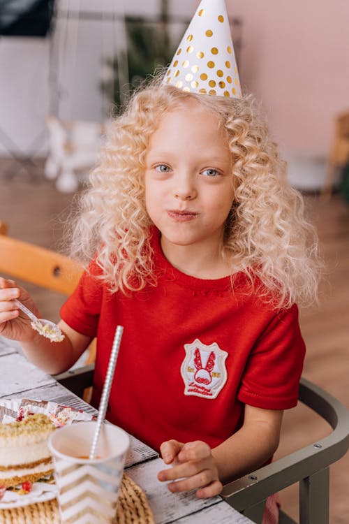 Free Girl in Red Crew Neck T-shirt Sitting on a Chair Stock Photo