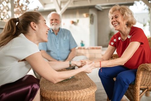 Free Three family members enjoying a happy conversation outside, sharing laughter and smiles. Stock Photo