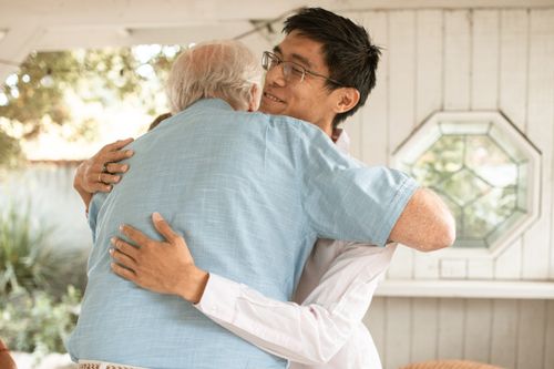 Free A touching moment of an adult and senior man embracing with joy and affection. Stock Photo