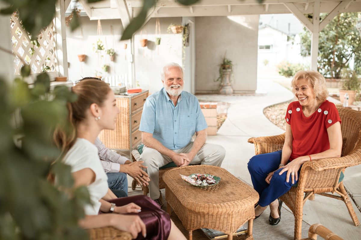 Familia disfrutando de una conversación relajada en un patio al aire libre con luz natural