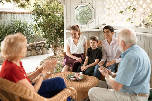 Free A diverse family enjoys a cheerful gathering in a cozy patio setting. Stock Photo