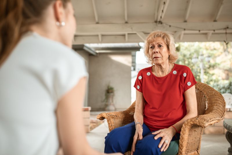 Mujer mayor conversando tranquilamente con una profesional