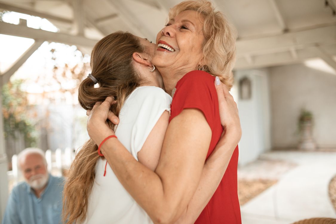 An elderly woman embraced in a comforting hug
