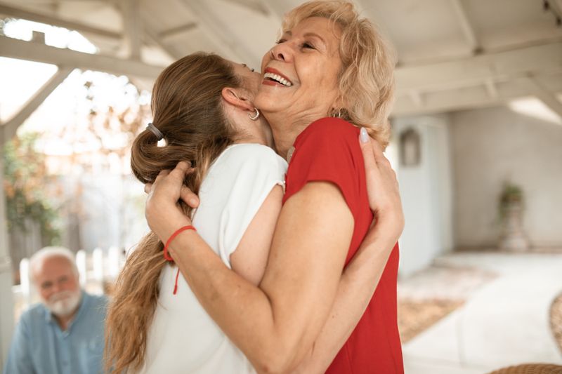 An elderly woman embraced in a comforting hug