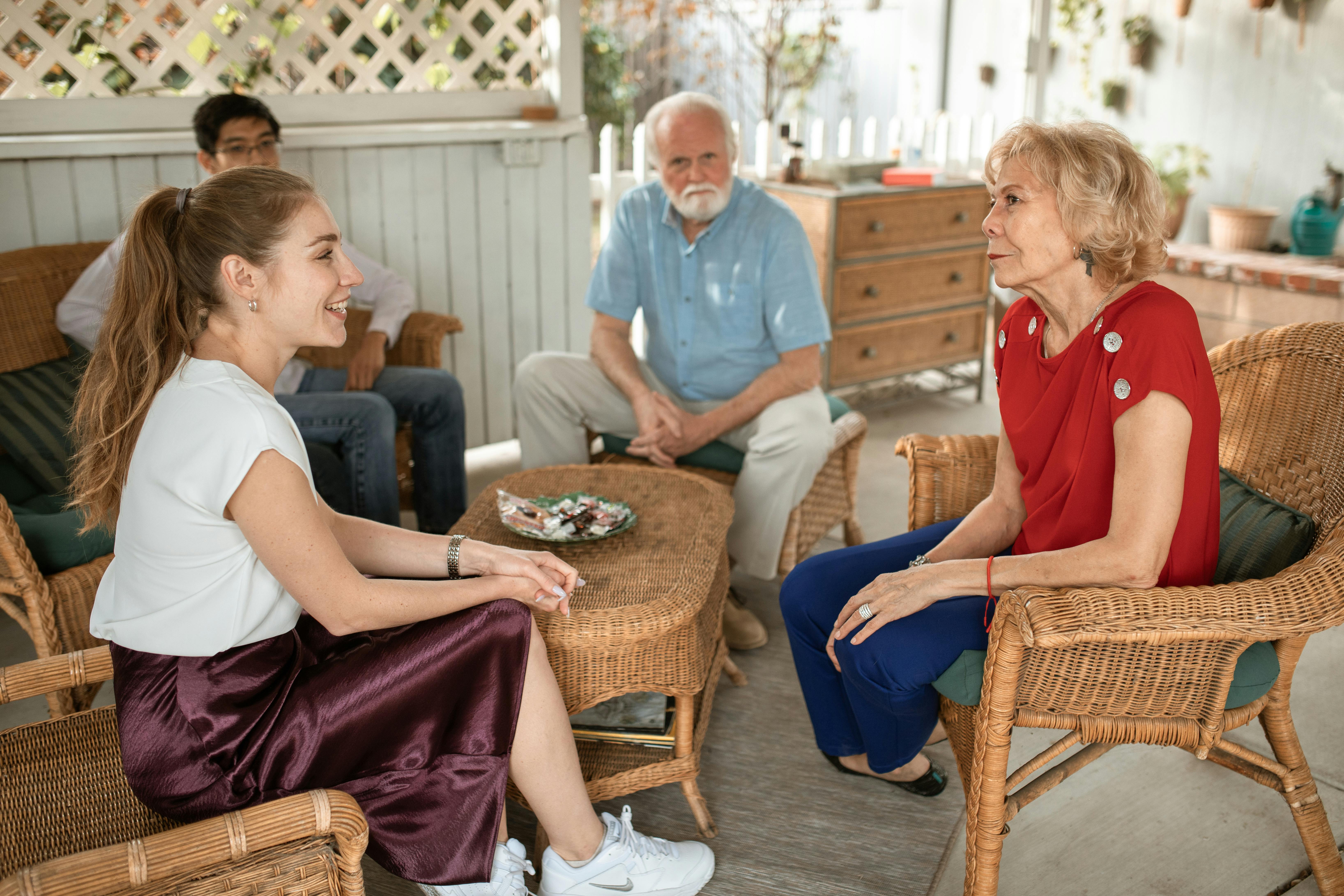 woman in blue polo shirt sitting on brown woven armchair