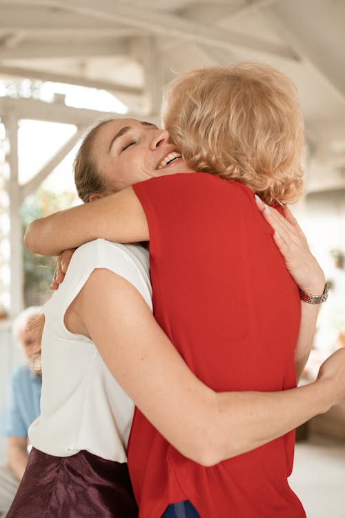 Женщина в белой майке с ребенком в красной рубашке