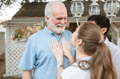 Free A joyful moment shared between a grandfather and his family outdoors on a sunny day. Stock Photo