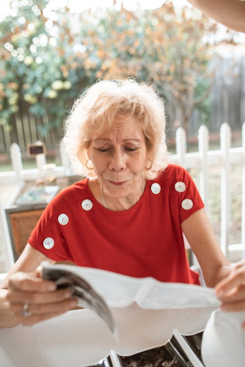 Elderly Woman Holding and Looking at the Paper 