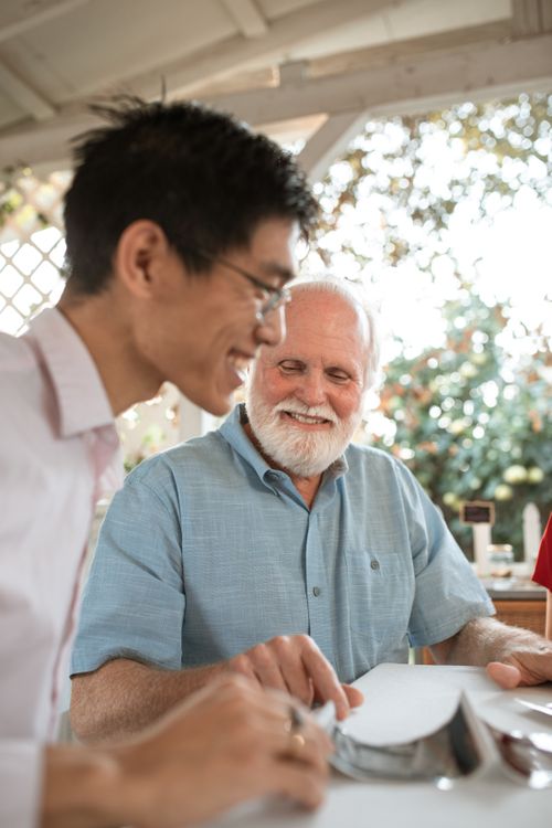 Free A senior man and an adult in a friendly conversation outdoors, enjoying a casual moment. Stock Photo