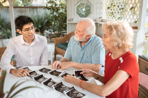 Free Family sits together discussing ultrasound images, celebrating new life. Stock Photo