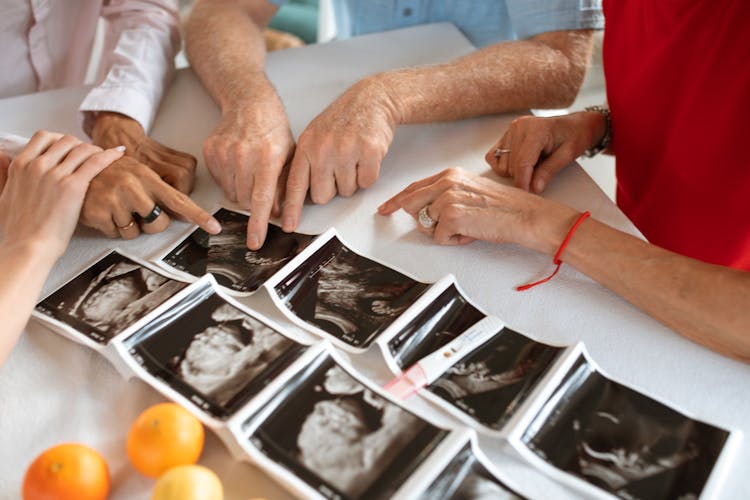 Hands Pointing The Picture On The Table 