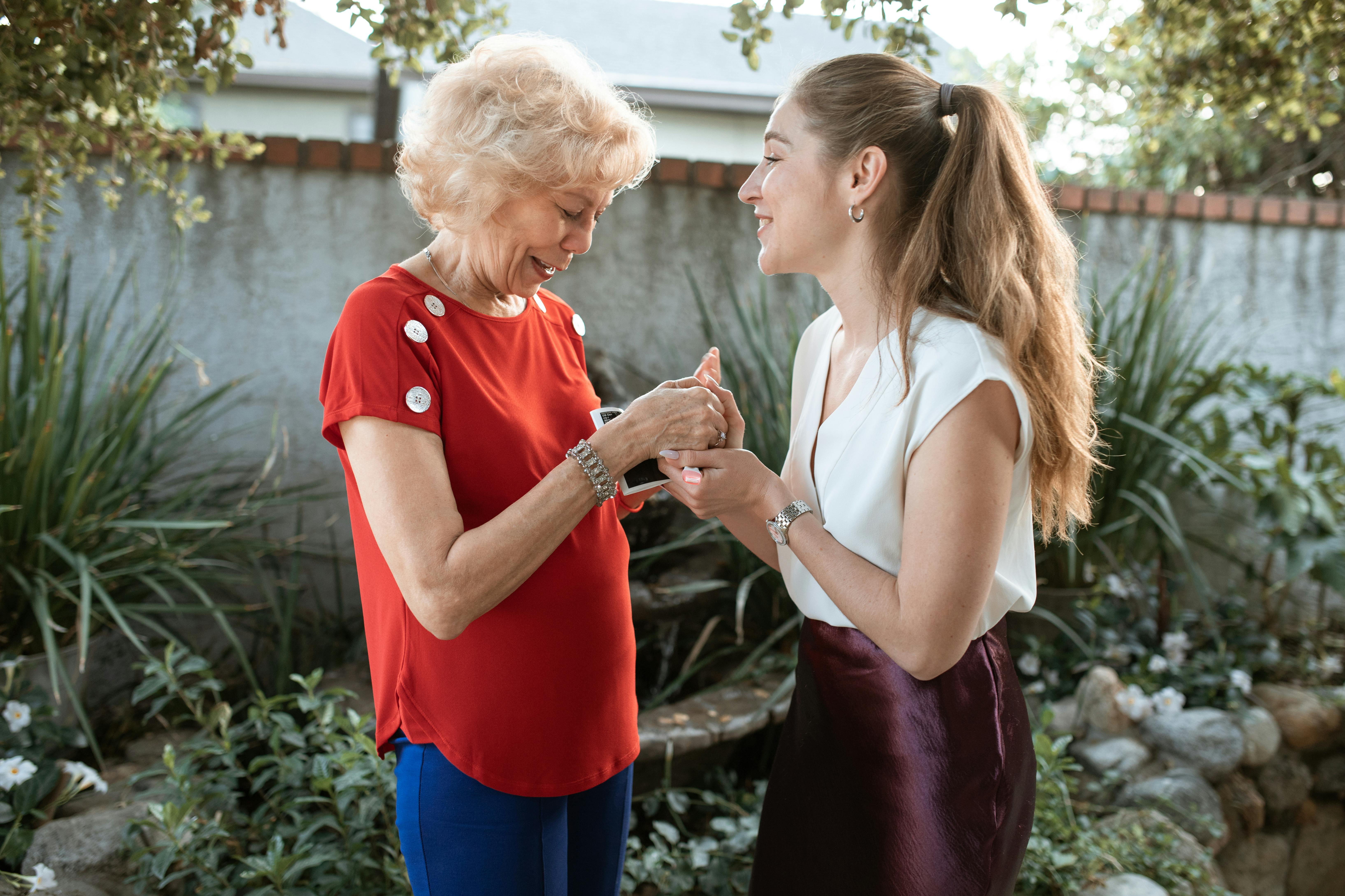 woman showing her mother she is pregnant