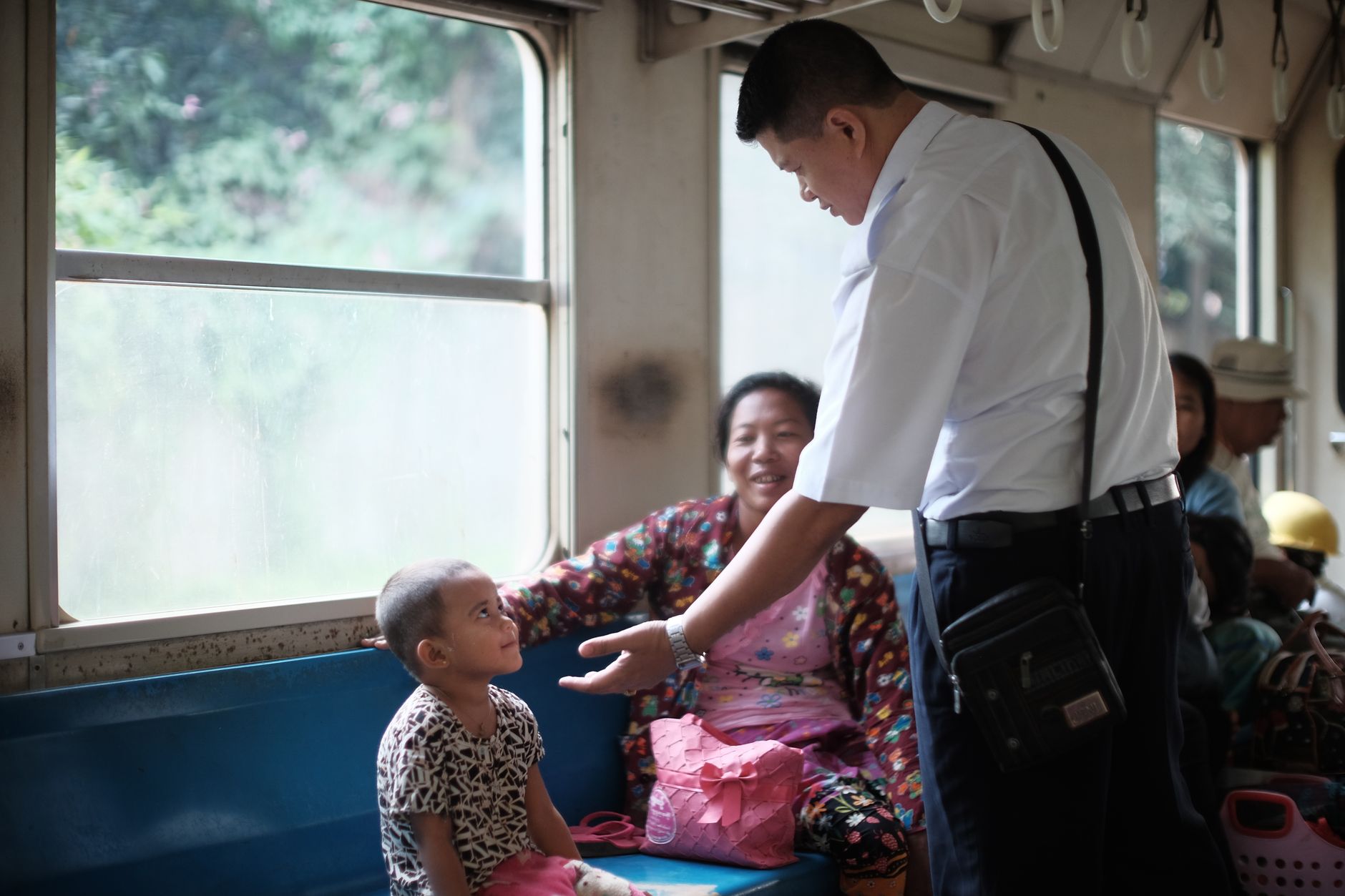 Autism-Friendly Train Travel: A Family Planning Guide A train conductor speaks warmly with a child and adult passenger in a carriage.