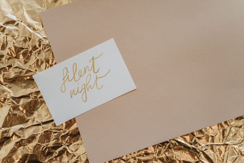 Gold foil sheet beside a hand-lettered calligraphy card