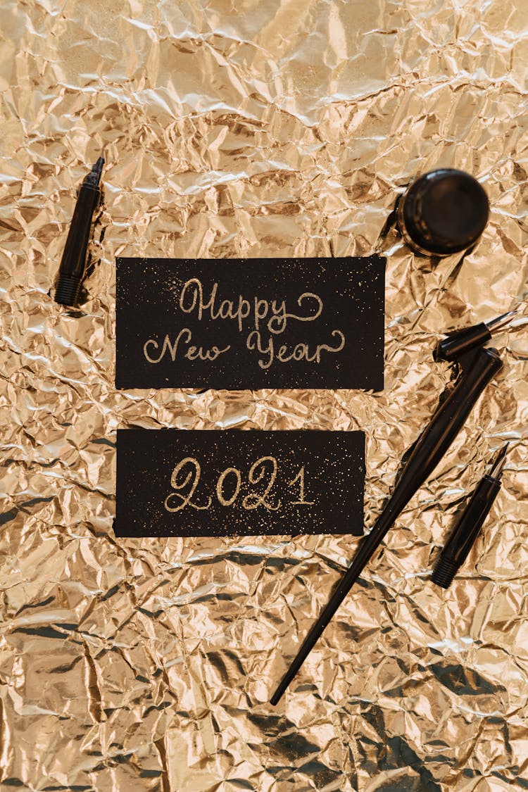 Happy New Year Written With A Gold Ink On A Black Paper 