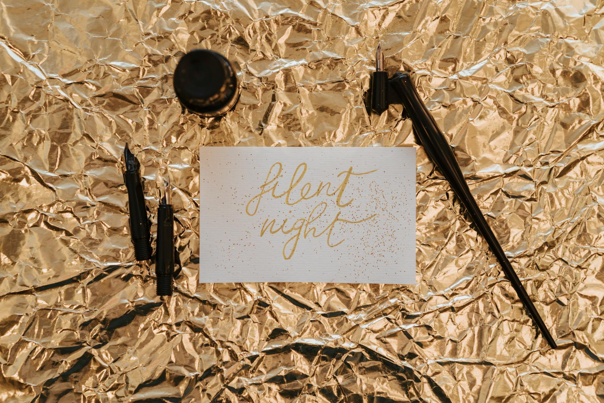 A sophisticated 'Silent Night' card featuring gold calligraphy on a crumpled foil background.