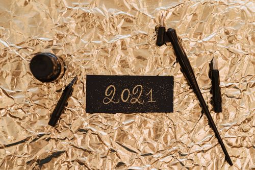 Free Minimalist 2021 calligraphy on gold foil with ink pens, ideal for New Year themes. Stock Photo