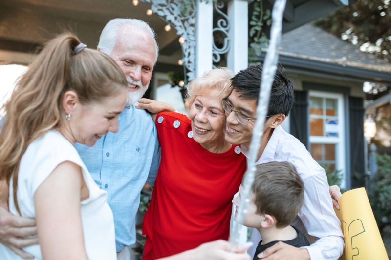 Three generations of a family hugging warmly at a Grandparents Day gathering