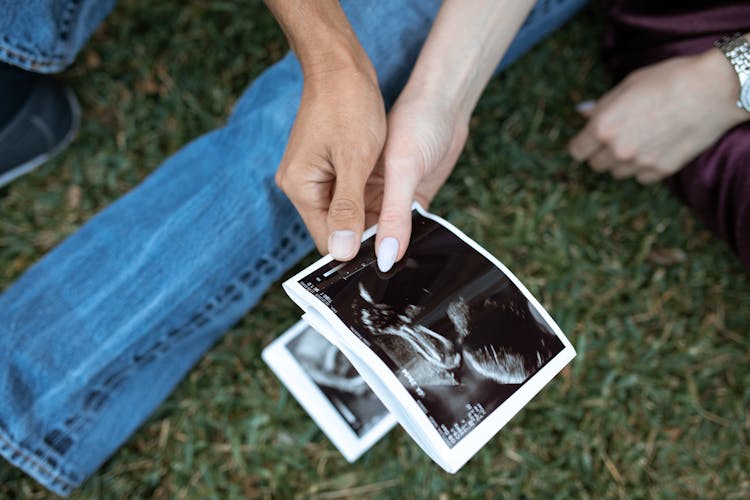 Hands Of Persons Holding A Black And White Photo