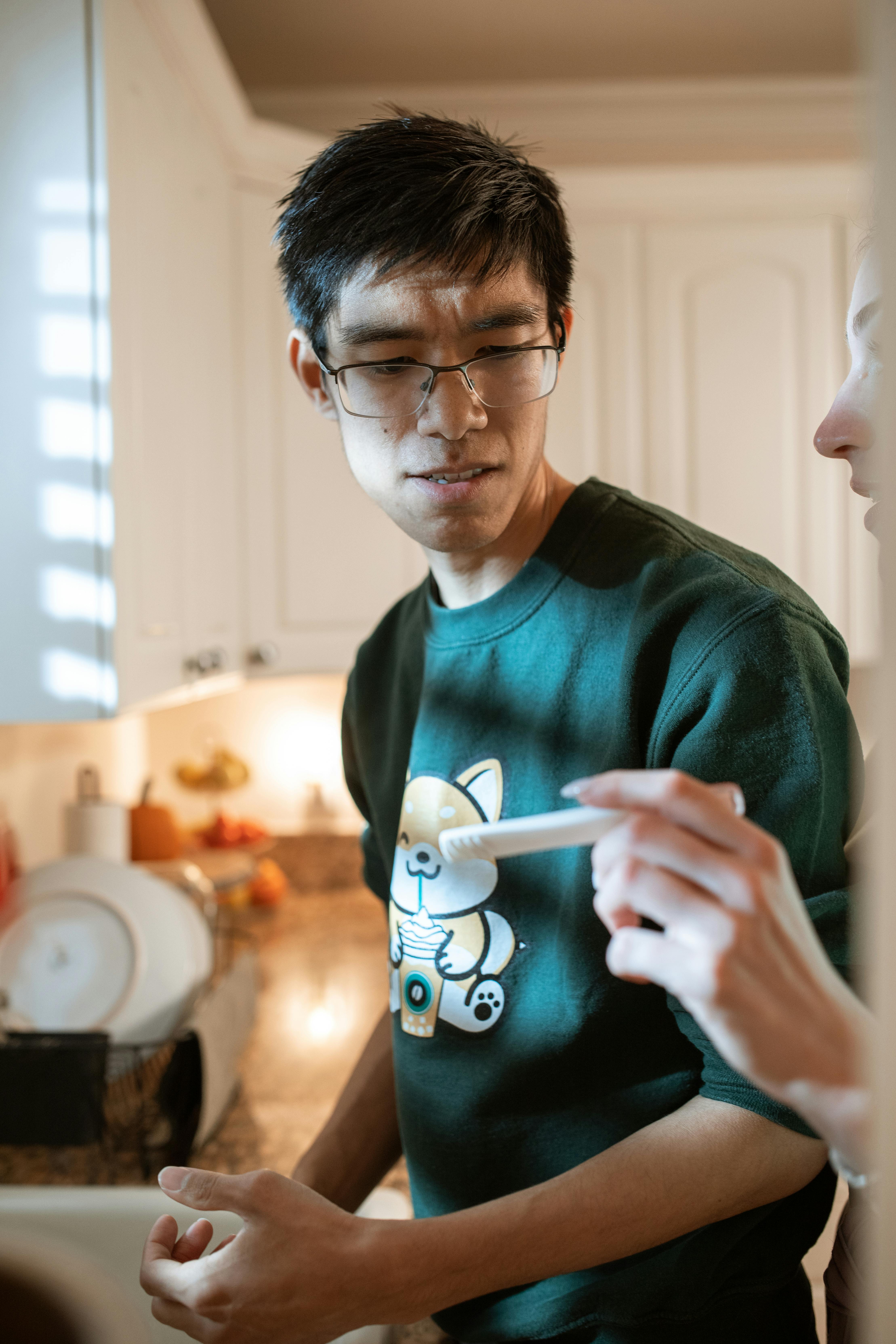 man in green sweater holding white ceramic mug