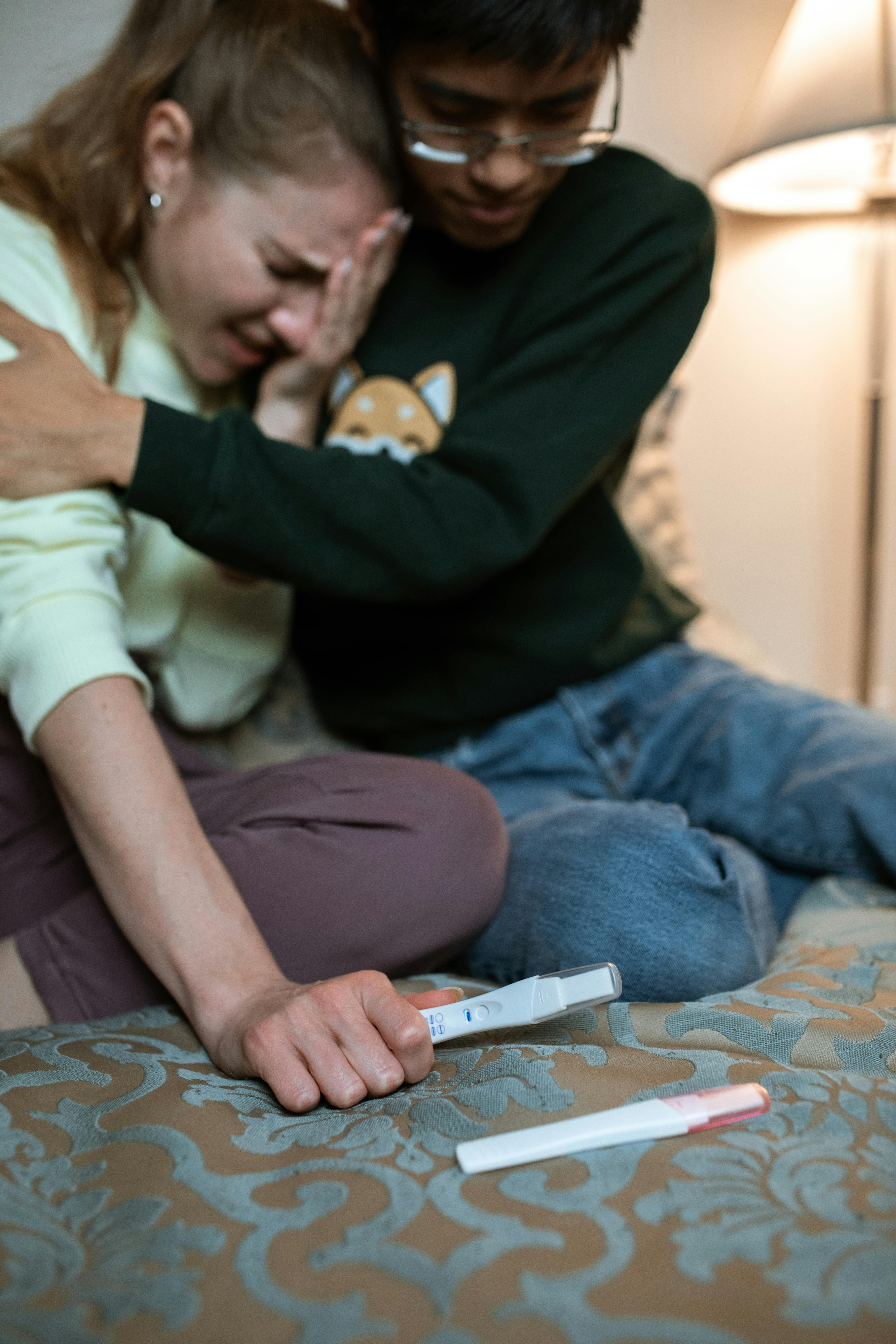 a woman holding a pregnancy test crying