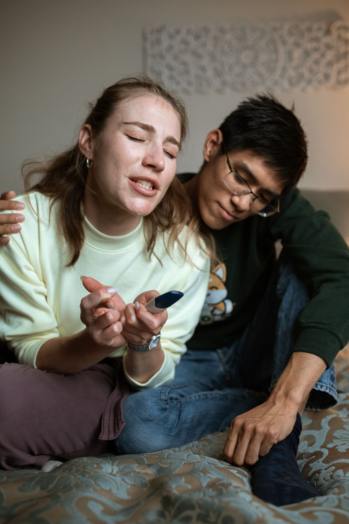 Couple waiting together while holding a pregnancy test