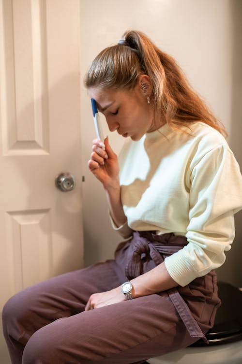 Free Woman in White Long Sleeve Shirt and Blue Denim Jeans Sitting on Floor Stock Photo
