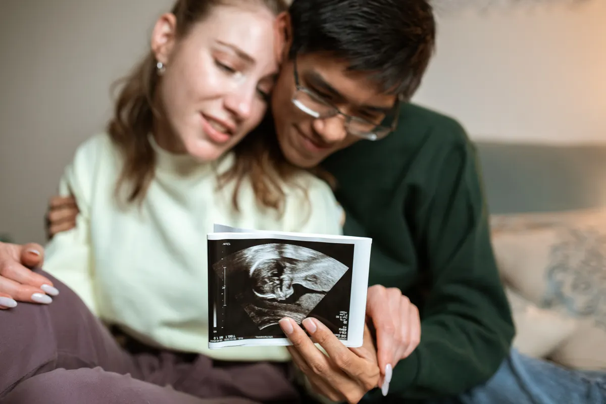 Couple looking at ultrasound image of baby in womb.