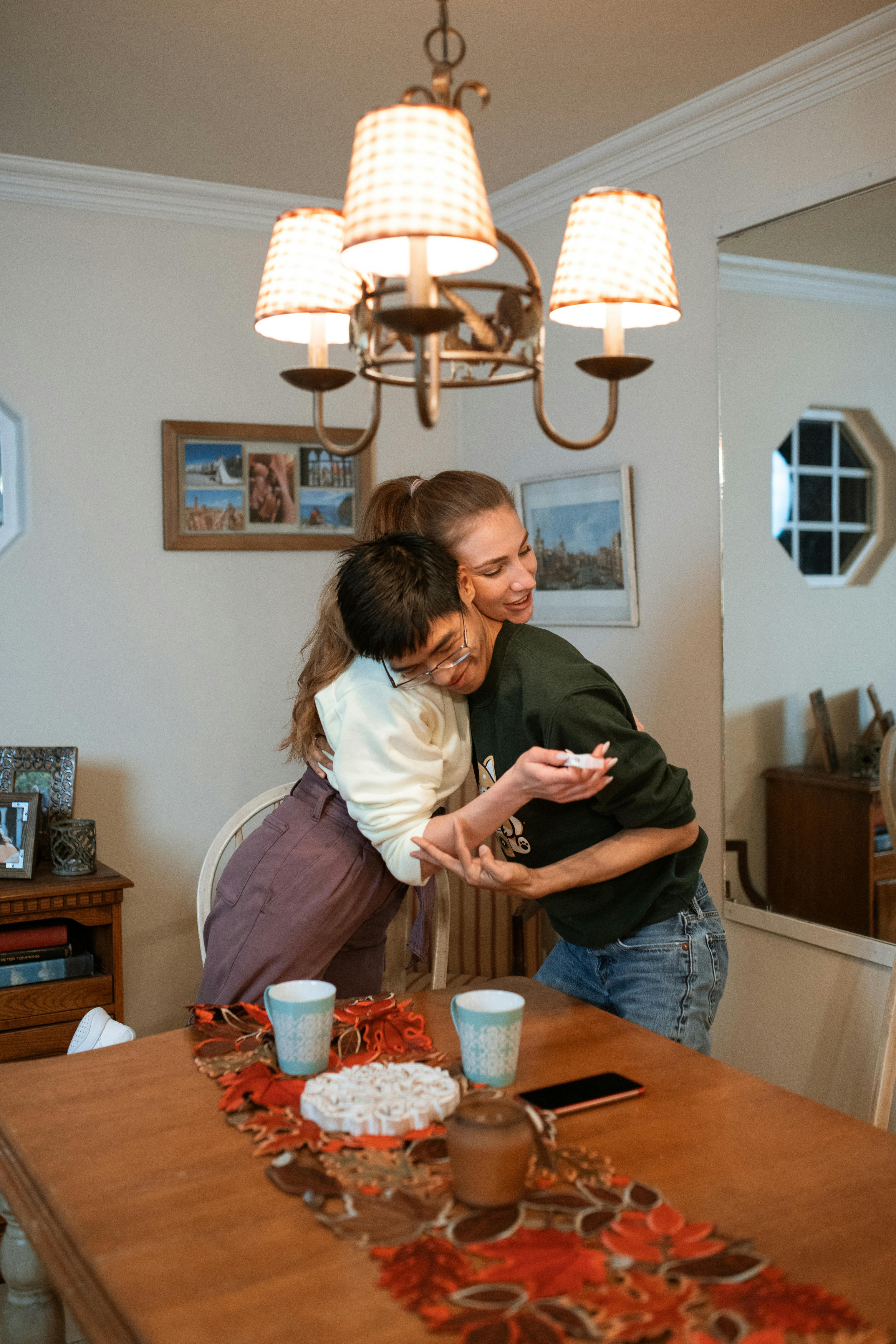 man in black sweater hugging woman in white shirt