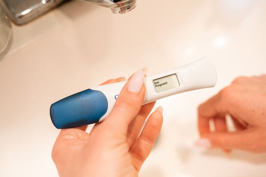 Close-up of a negative pregnancy test displayed by a woman's hand.