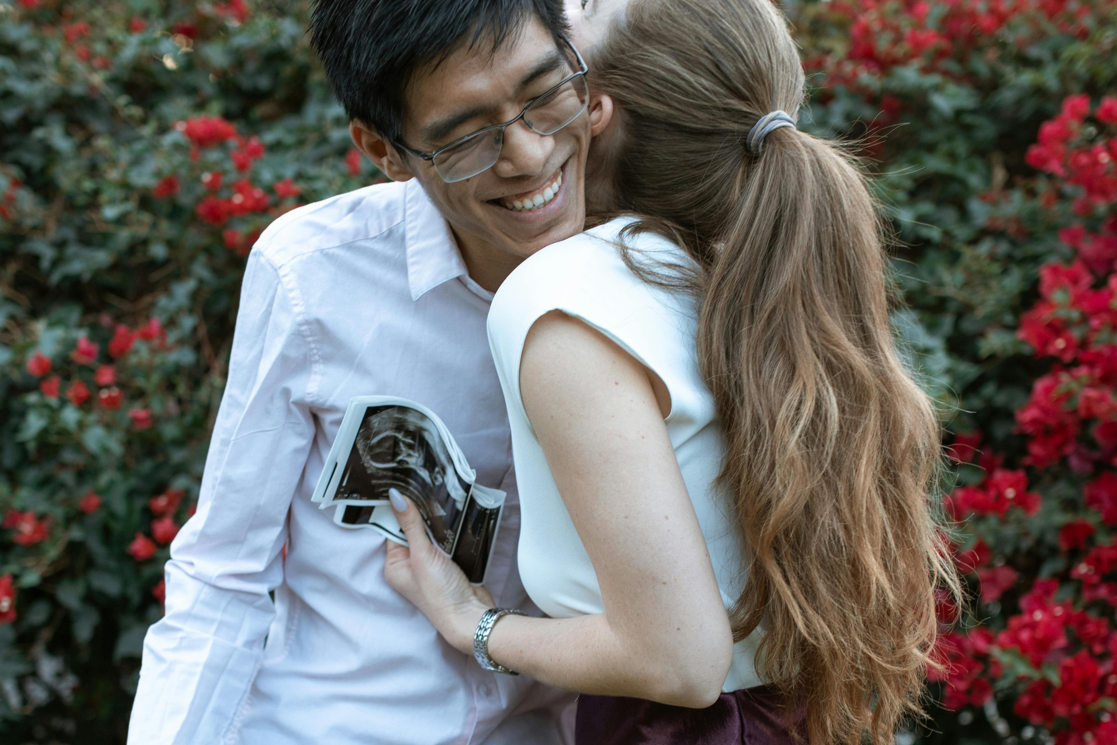 woman in white tank top holding black smartphone