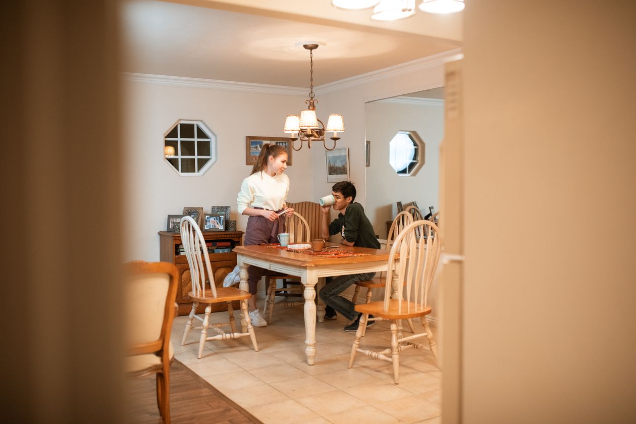 A couple at a kitchen table talking honestly under a warm lamp.