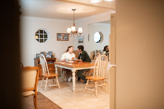 Couple enjoying a relaxed conversation in a cozy dining room setting.