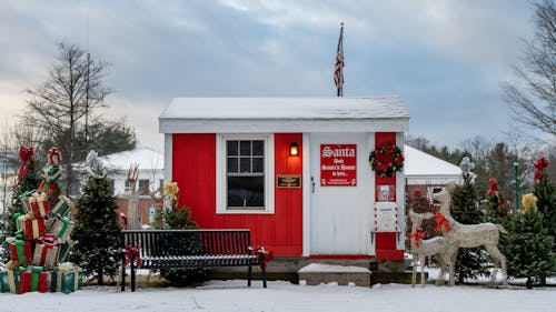 Red Santa house with Christmas presents in winter