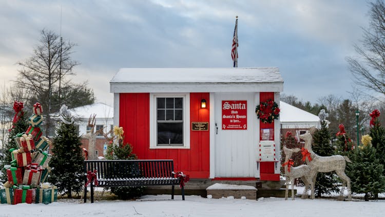 Red Santa House With Christmas Presents In Winter