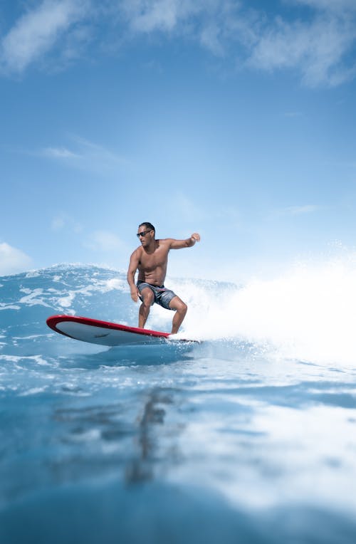 Male in swimwear surfing in water