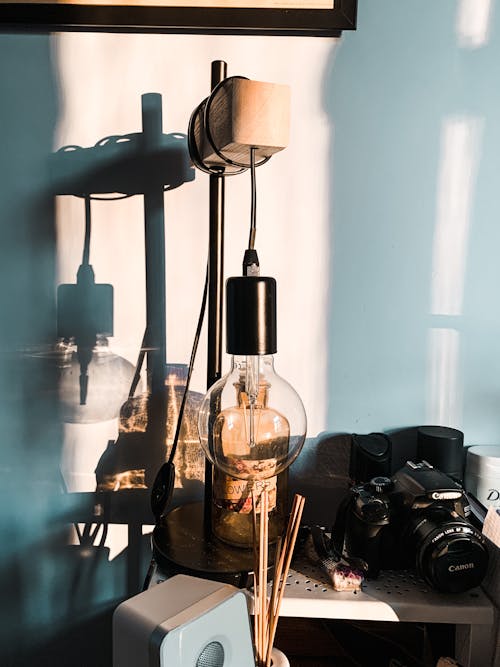 Vintage lamp on shelf near photo camera