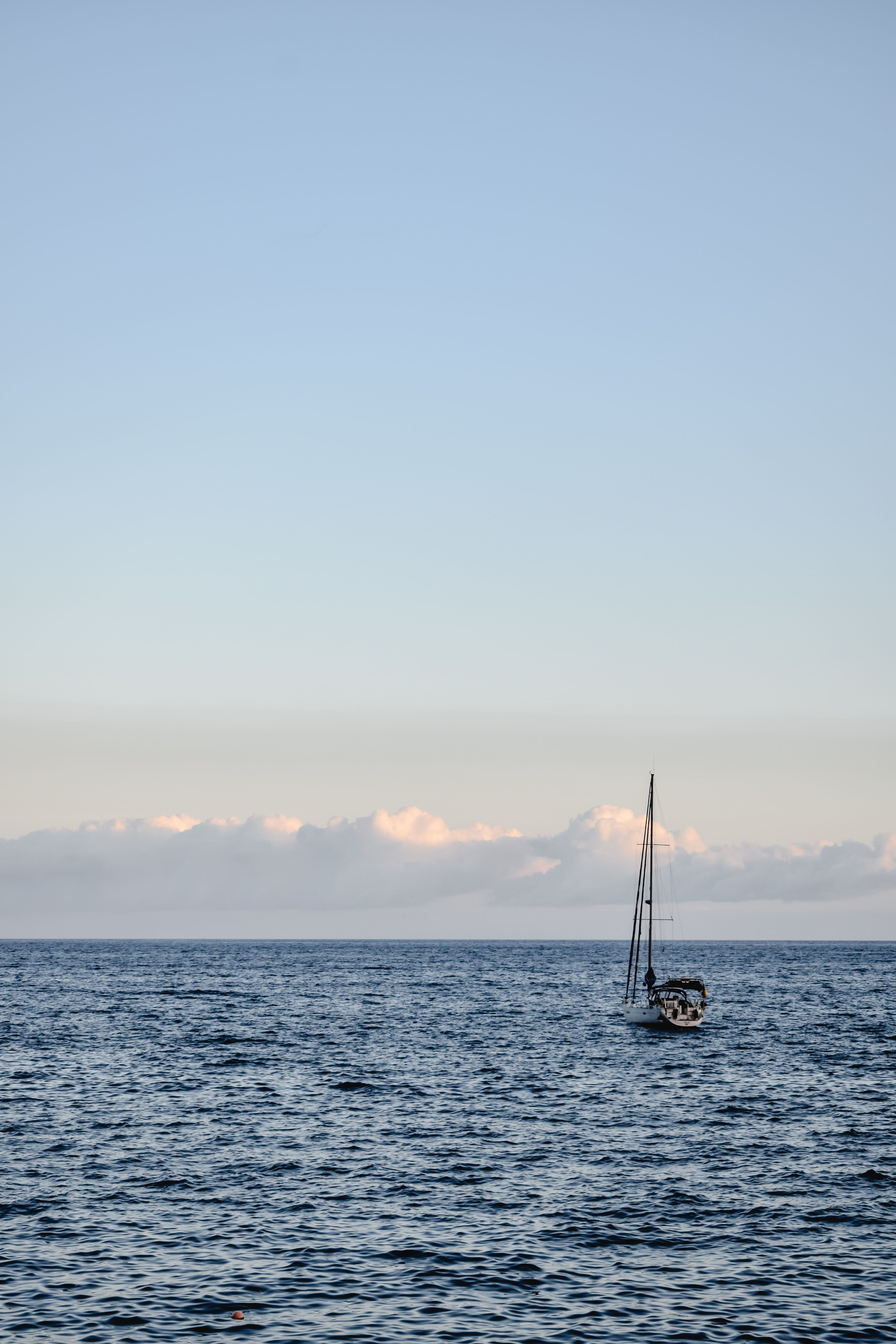 Sailboat sailing on a serene ocean at sunset