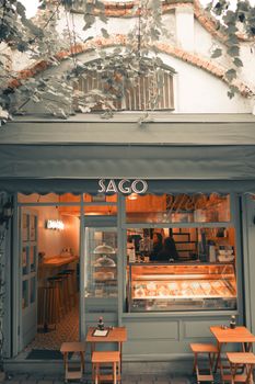 Inviting café entrance with warm interior lighting and outdoor seating.