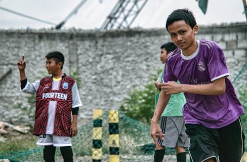 Ethnic boys playing football on street