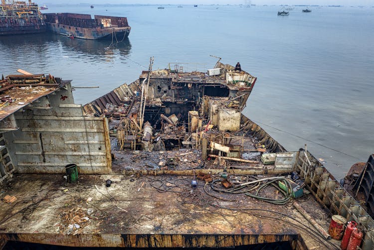 Abandoned Ship With Rubbish Floating In Sea