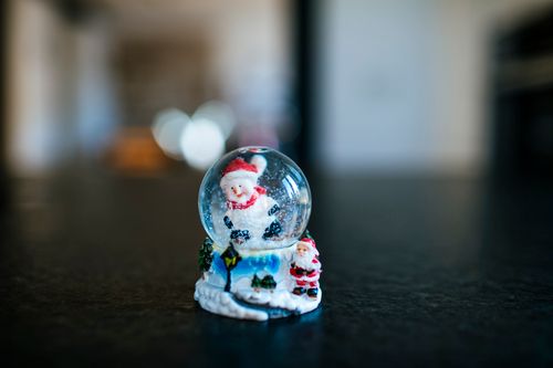 Free Close-up of a Christmas snow globe featuring a Santa Claus figurine, perfect for holiday decor. Stock Photo