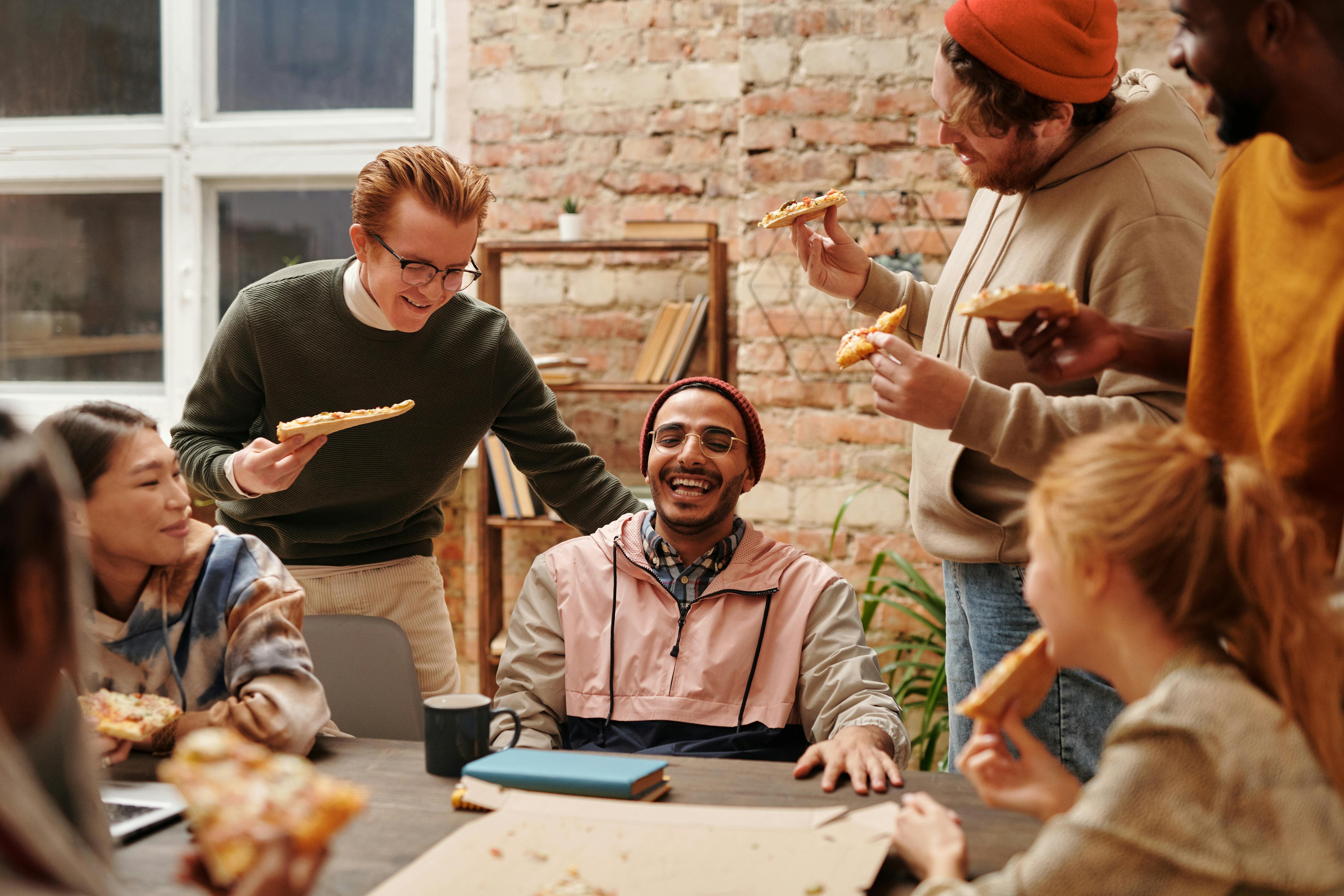 Happy Friends hanging out Together and eating Pizza · Free Stock Photo