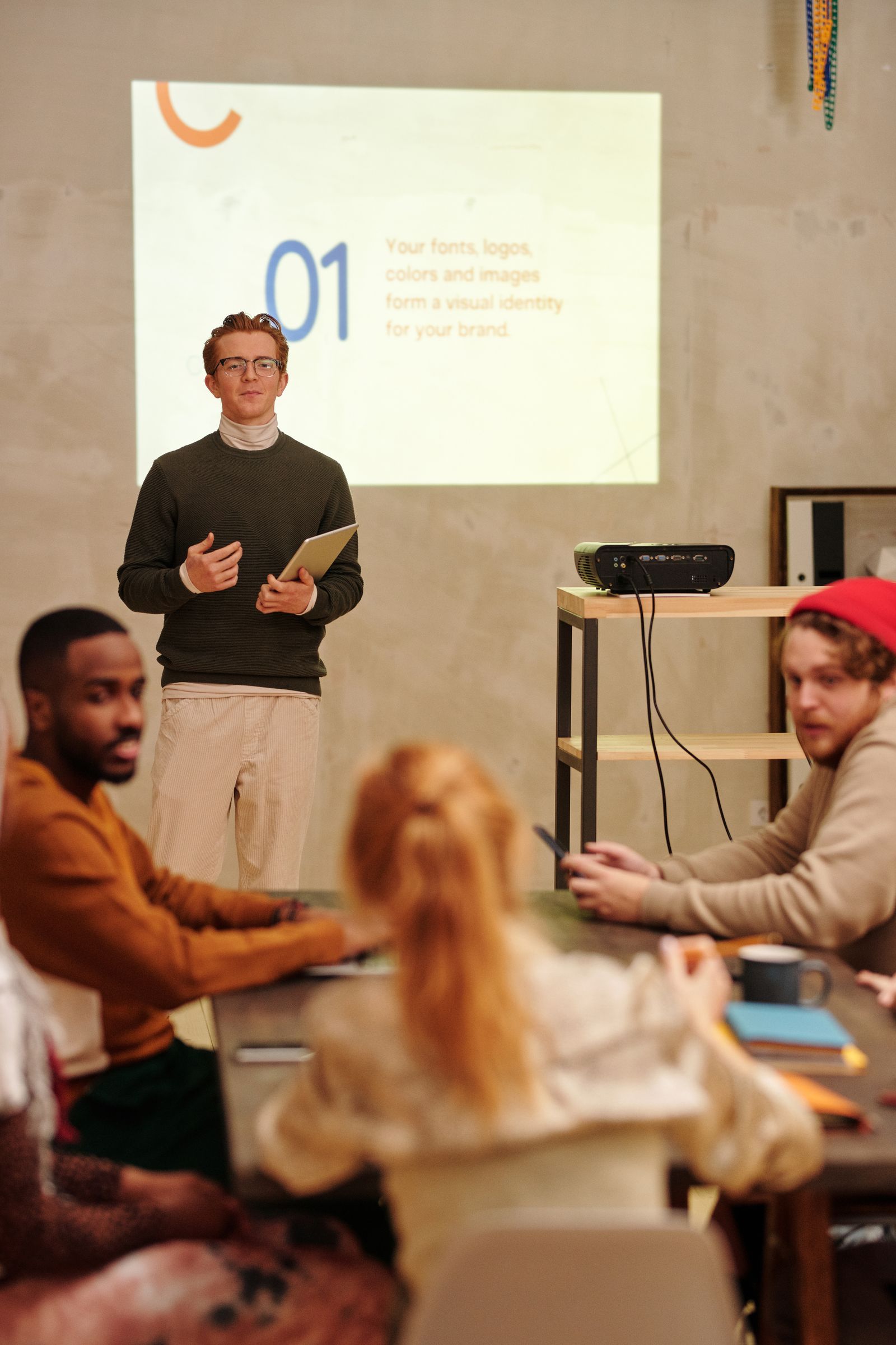 A group of colleagues around a table in a modern office following a presentation with visual aids